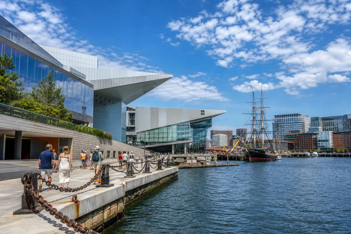 Photoreal Boston harborfront cultural district with modern museum architecture and historic ship in daylight