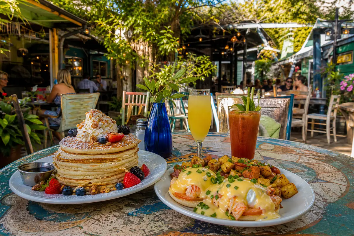 Photoreal tropical courtyard brunch scene representing Blue Heaven in Key West