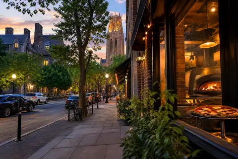 Photoreal travel-editorial scene for A New Haven Weekend Guide for Yale, Pizza, and East Rock