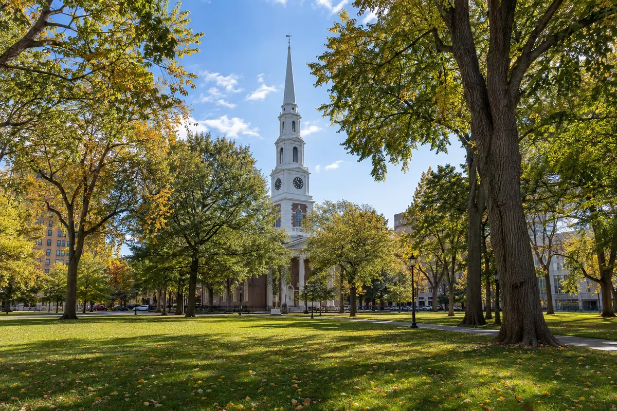 Photoreal travel-editorial view of New Haven Green and Center Church on the Green in New Haven, Connecticut