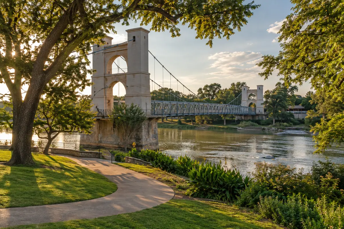 Photoreal travel-editorial view of Waco Suspension Bridge and Indian Spring Park in Waco, Texas